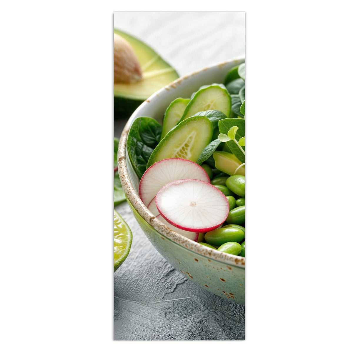 Grüne Schale mit Spinat, Gurke, Edamame, Radieschen und Sprossen, halbe Avocado und Limette daneben