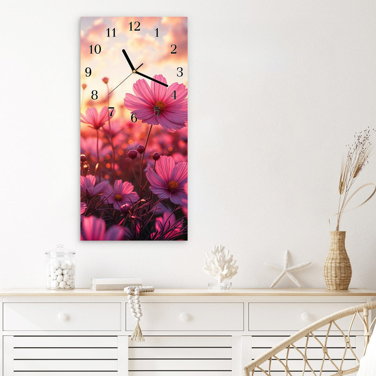 Wanduhr aus Glas im Hochformat Cosmeen im Abendlicht mit Ziffernblatt Klassisch über einem weißen Sideboard