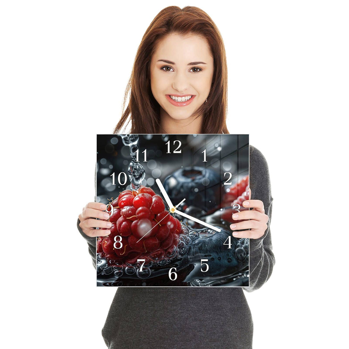 Quadratische Wanduhr aus Glas Himbeere und Blaubeeren in zwei Händen gehalten – Größenvergleich, 30 × 30 cm