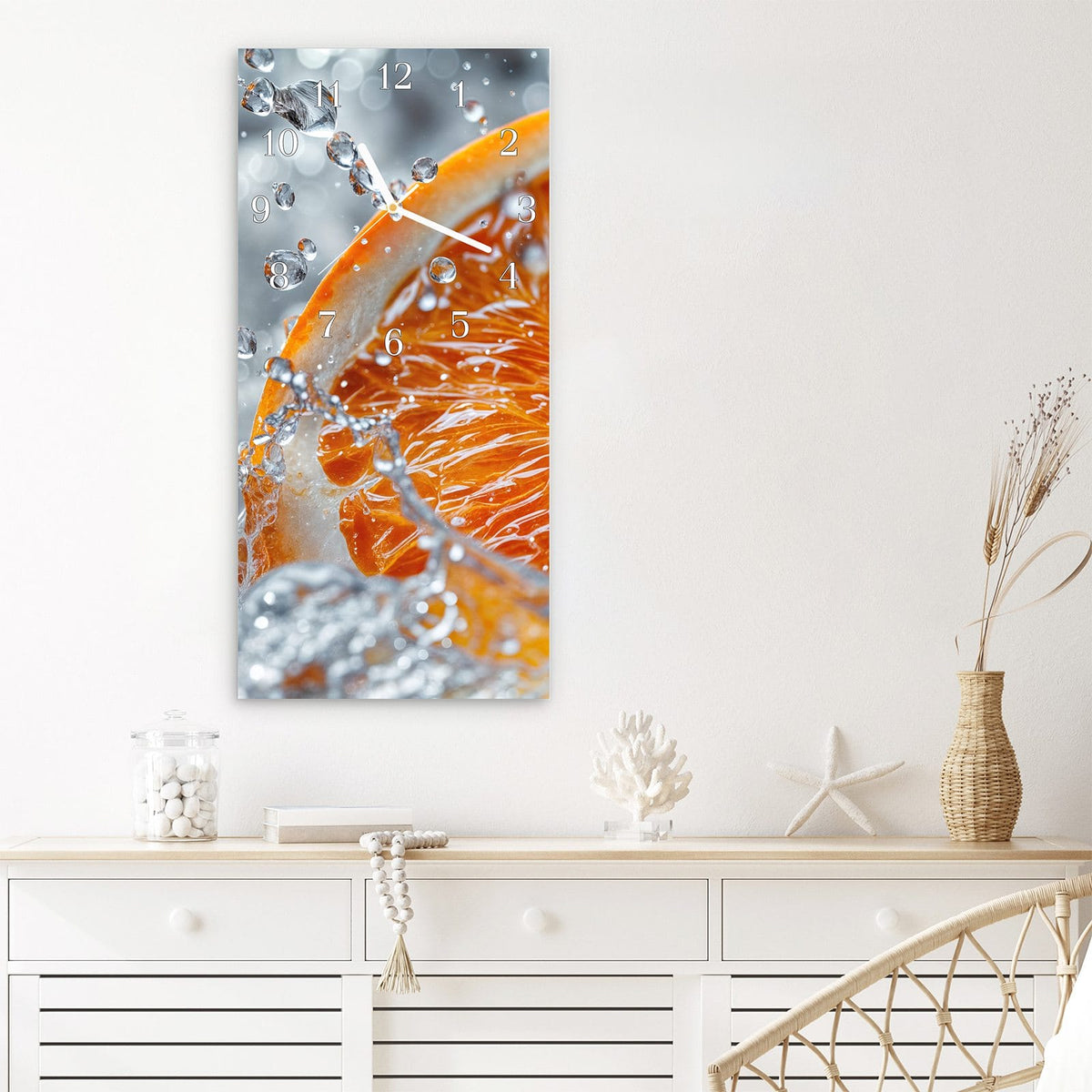Wanduhr aus Glas im Hochformat Orangenscheibe im Wasser mit Ziffernblatt Klassisch über einem weißen Sideboard