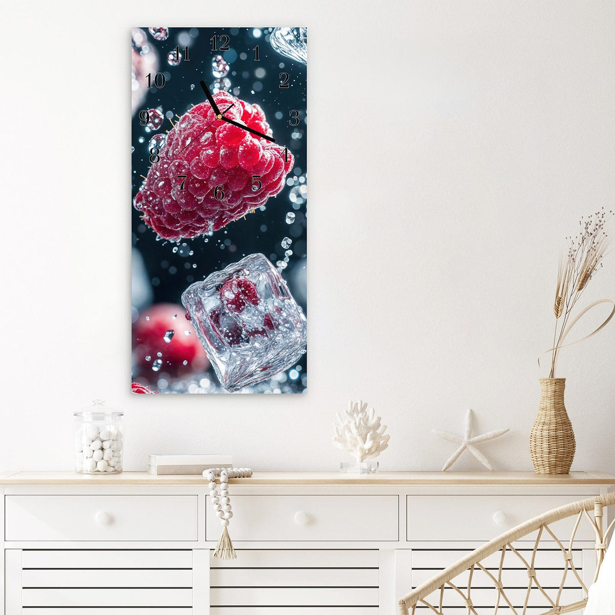 Wanduhr aus Glas im Hochformat Himbeeren und Eiswürfel mit Ziffernblatt Klassisch über einem weißen Sideboard