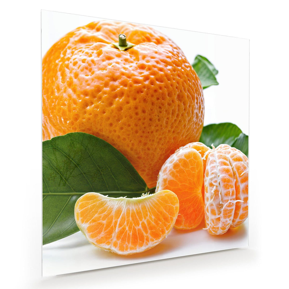 Ganze Mandarine mit grünen Blättern, davor geschälte Frucht und einzelne Spalten vor Weiß
