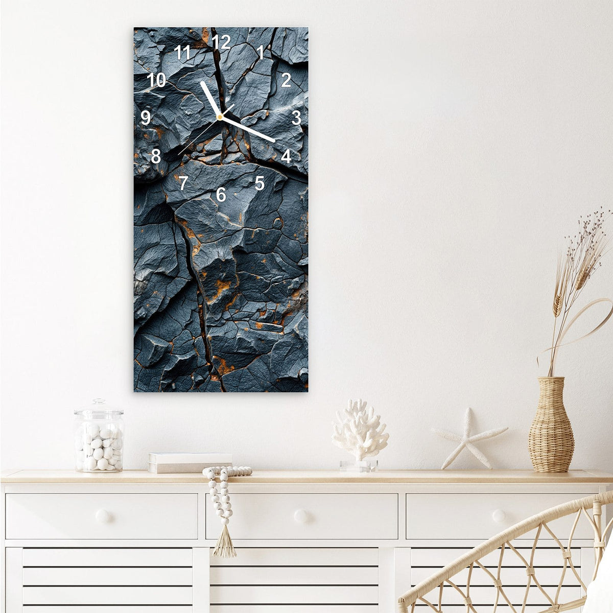 Wanduhr aus Glas im Hochformat Zerklüfteter Fels mit Ziffernblatt Modern über einem weißen Sideboard