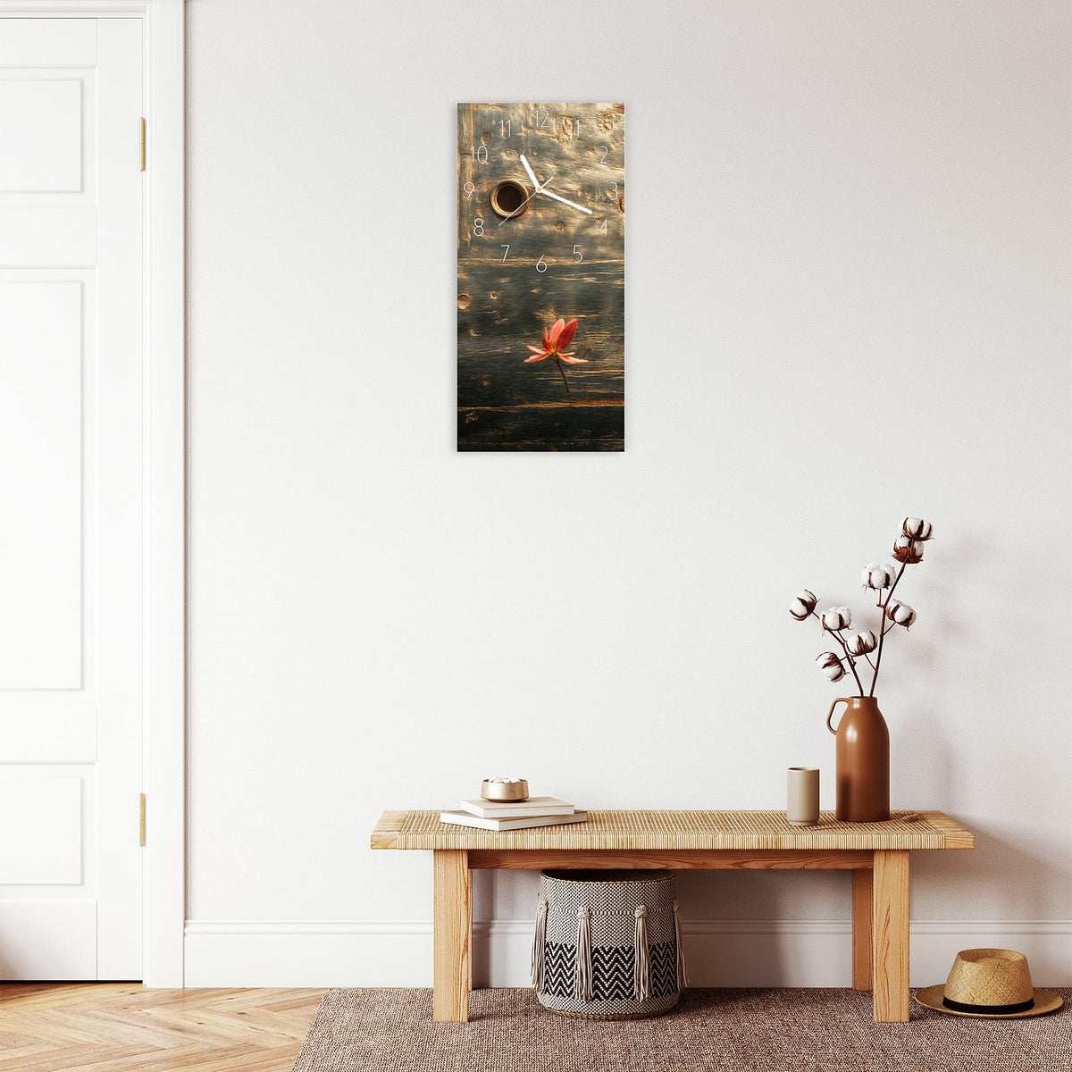 Wanduhr aus Glas im Hochformat Rote Blüten am Metall mit Ziffernblatt Elegant über einer Holzbank im Flur