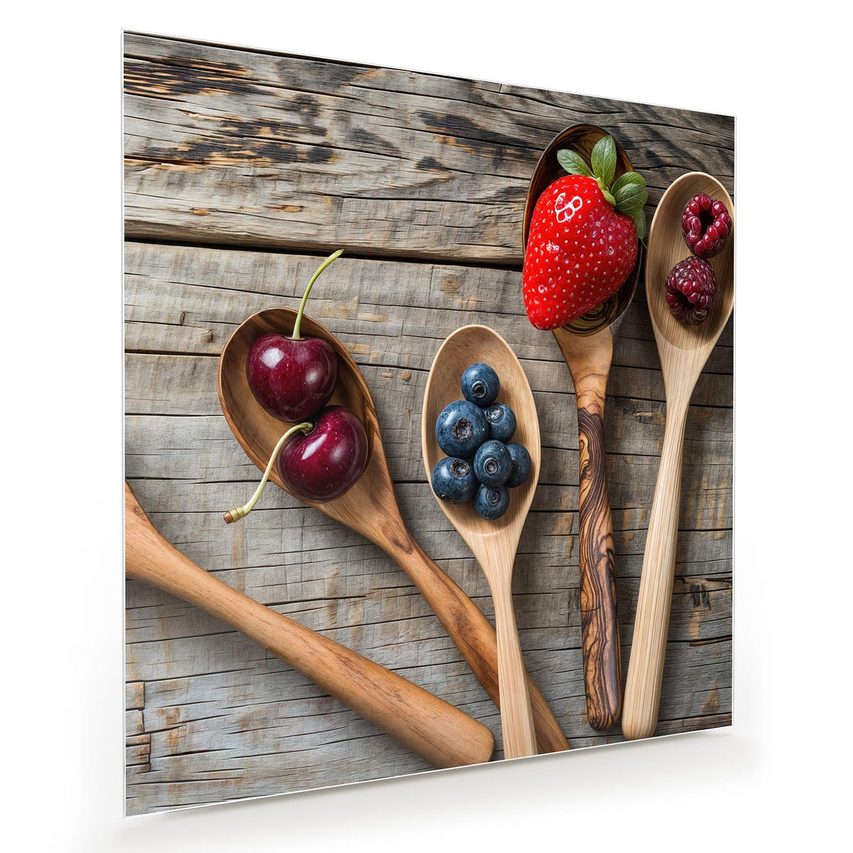Vier Holzlöffel mit Kirschen, Blaubeeren, Erdbeere und Himbeeren auf grauem Holz