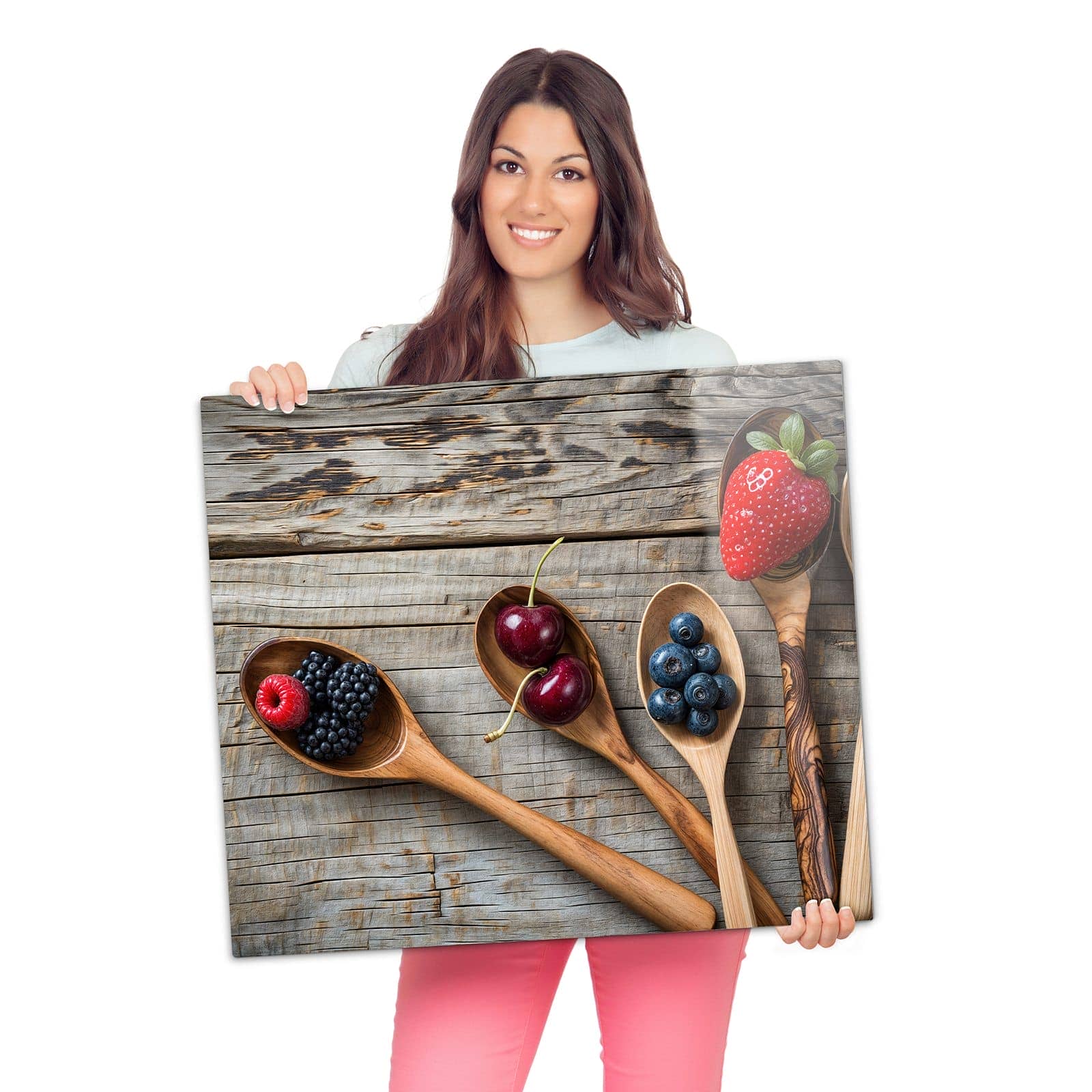 Glasplatte für Herd mit Holzlöffel mit Beeren-Motiv wird zur Größendarstellung gehalten