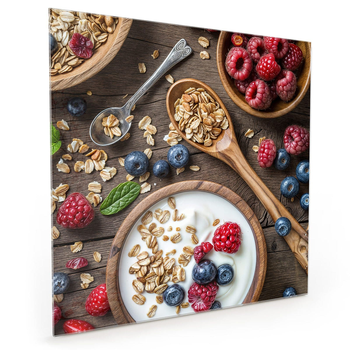 Küchenrückwand aus Glas im quadratischen Format mit Motiv Joghurt mit Beeren: Schale mit Joghurt, Haferflocken, Himbeeren und Blaubeeren #grösse_40 x 40 cm #grösse_50 x 50 cm #grösse_60 x 60 cm