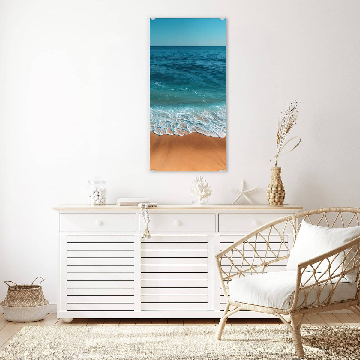 Wandbild aus Glas Azurblaues Meer über einem weißen Sideboard neben einem Rattansessel
