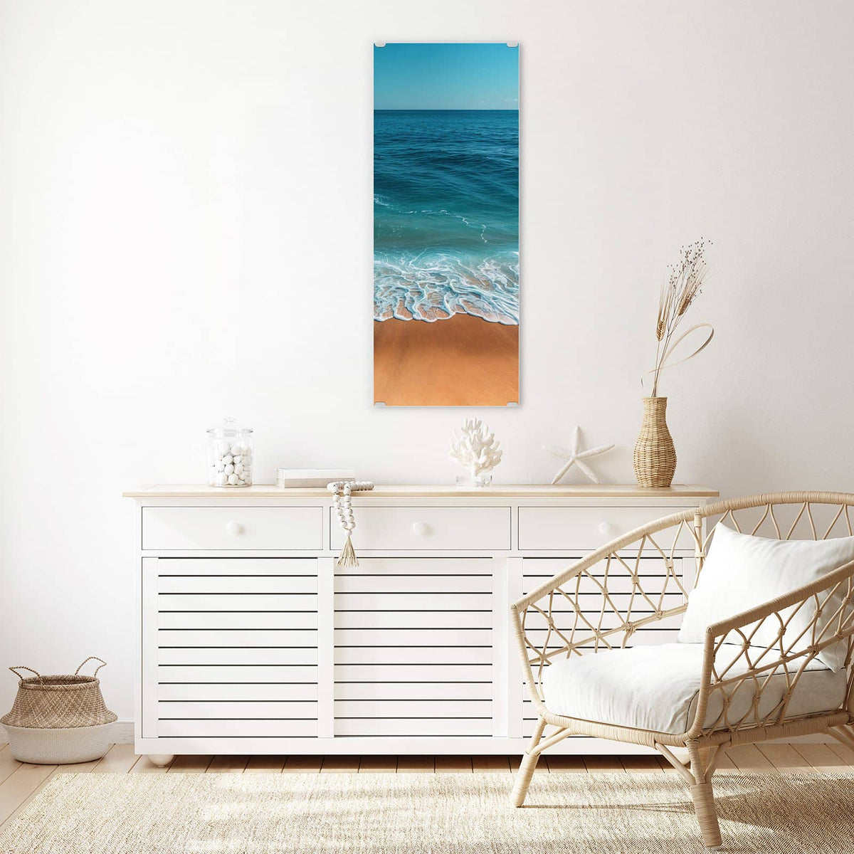 Wandbild aus Glas Azurblaues Meer über einem weißen Sideboard neben einem Rattansessel