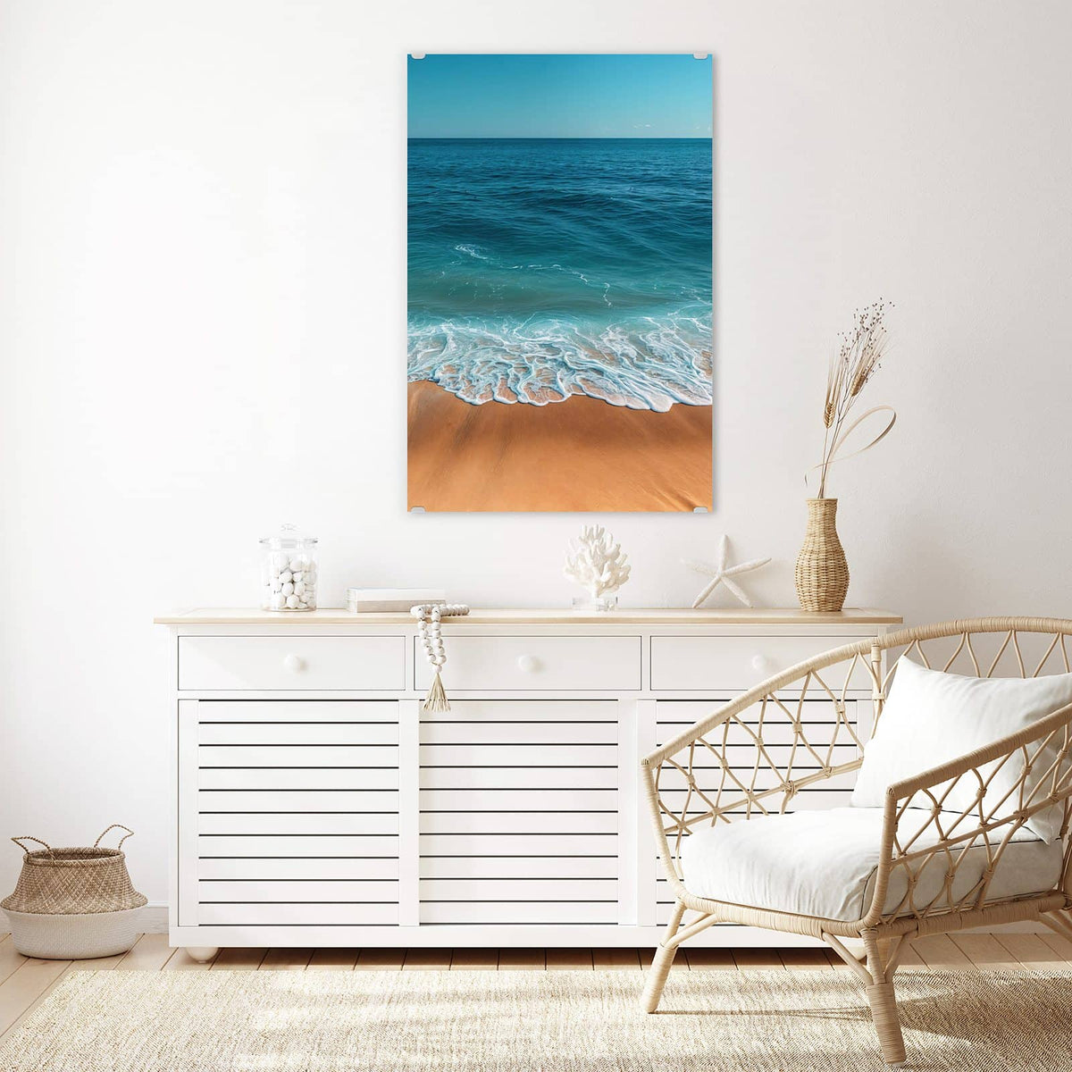 Wandbild aus Glas Azurblaues Meer über einem weißen Sideboard neben einem Rattansessel