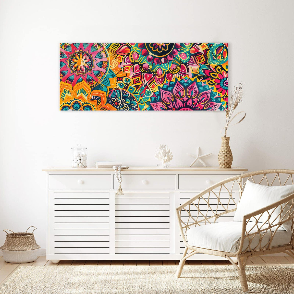 Wandbild aus Glas Bunte Mandalas über einem weißen Sideboard neben einem Rattansessel