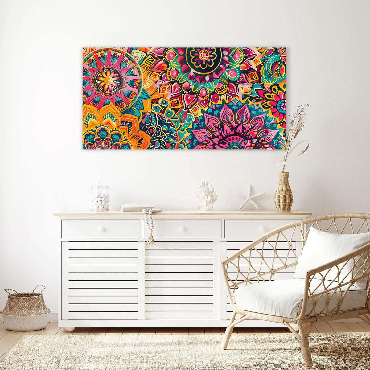 Wandbild aus Glas Bunte Mandalas über einem weißen Sideboard neben einem Rattansessel
