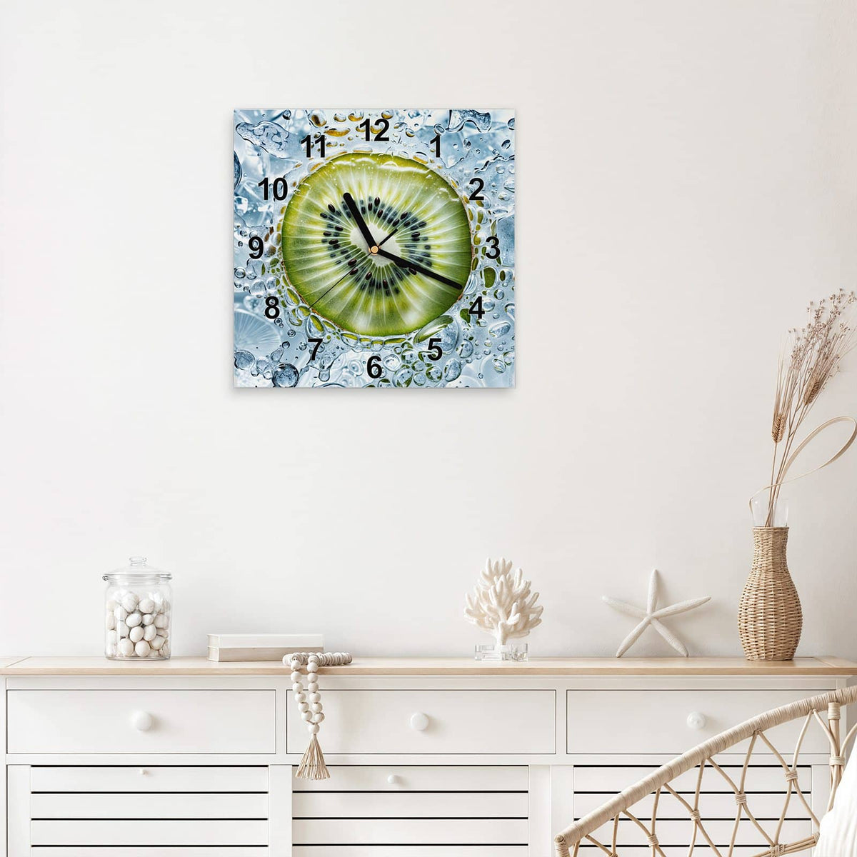 Quadratische Wanduhr aus Glas Kiwi in Wasserblasen mit Ziffernblatt Modern über einem weißen Sideboard