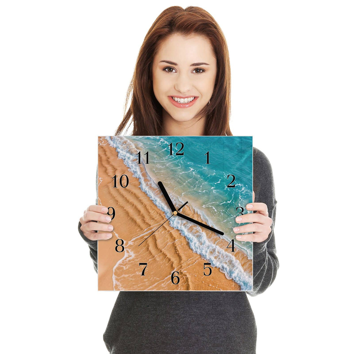 Quadratische Wanduhr aus Glas Sandrippen am Ufer in zwei Händen gehalten – Größenvergleich, 30 × 30 cm
