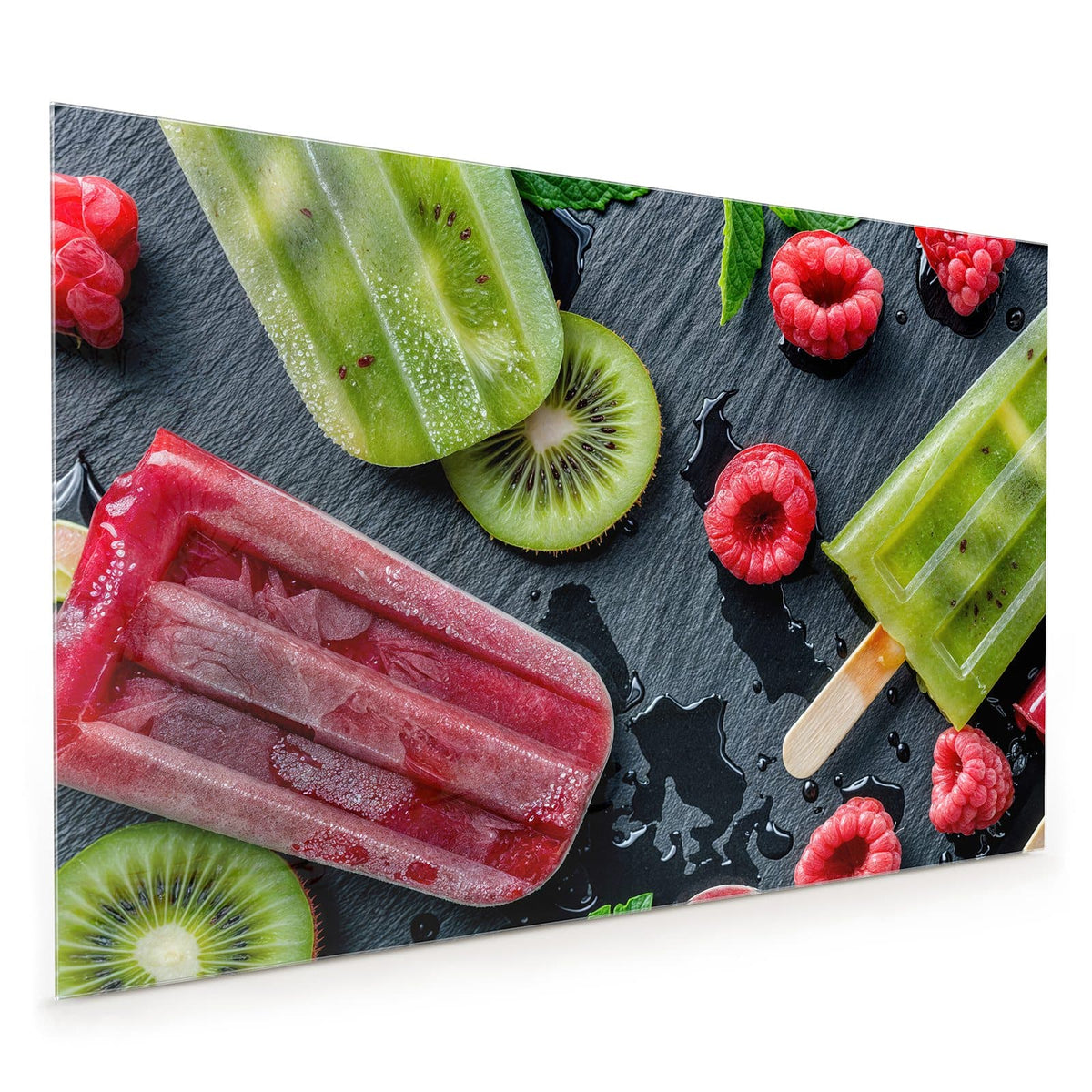 Küchenrückwand aus Glas im Hochformat mit Motiv Fruchteis auf Schiefer: Grünes Kiwi-Eis und rotes Beereneis am Stiel auf dunkler Schieferplatte