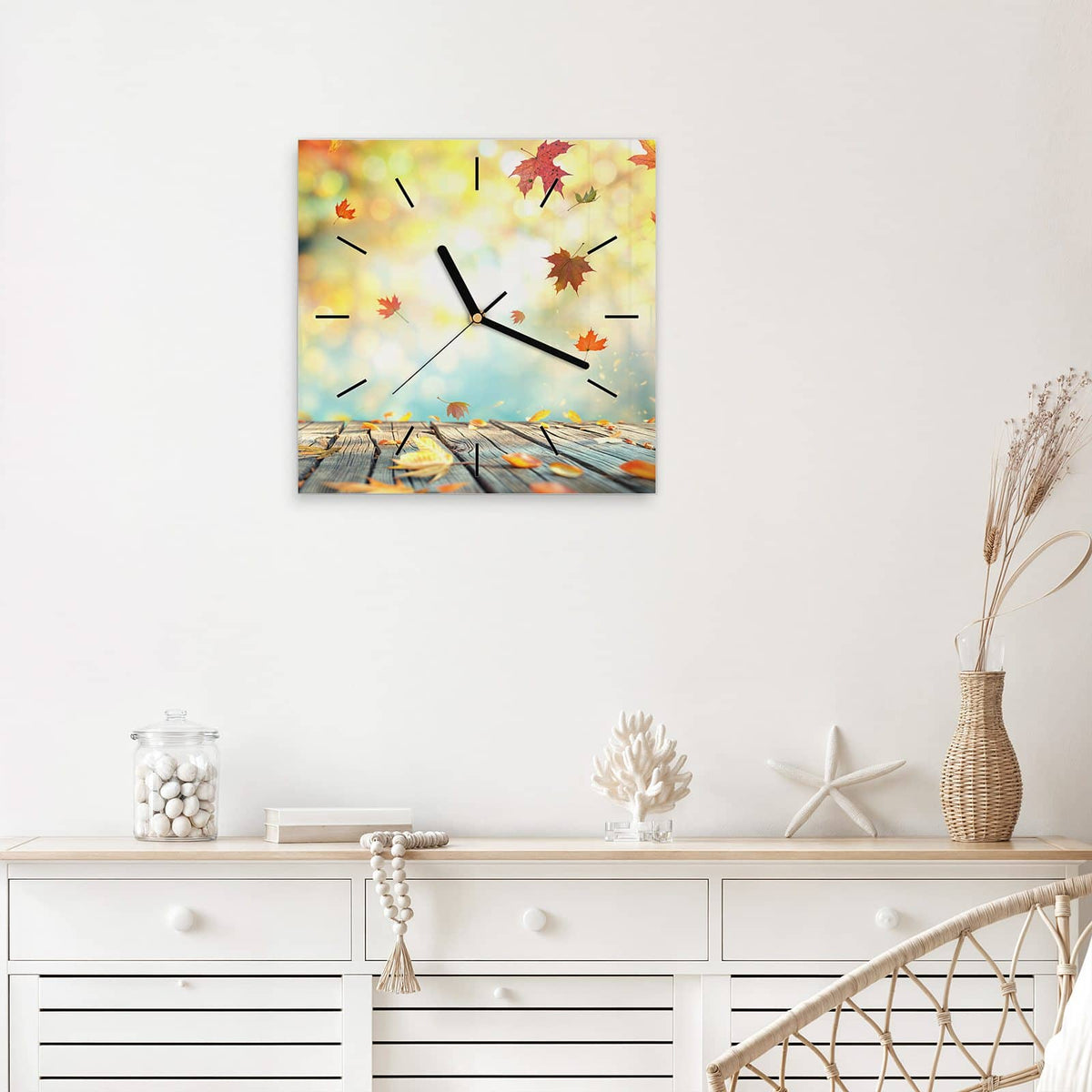 Quadratische Wanduhr aus Glas Herbstlaub auf Holz mit Ziffernblatt Linie über einem weißen Sideboard