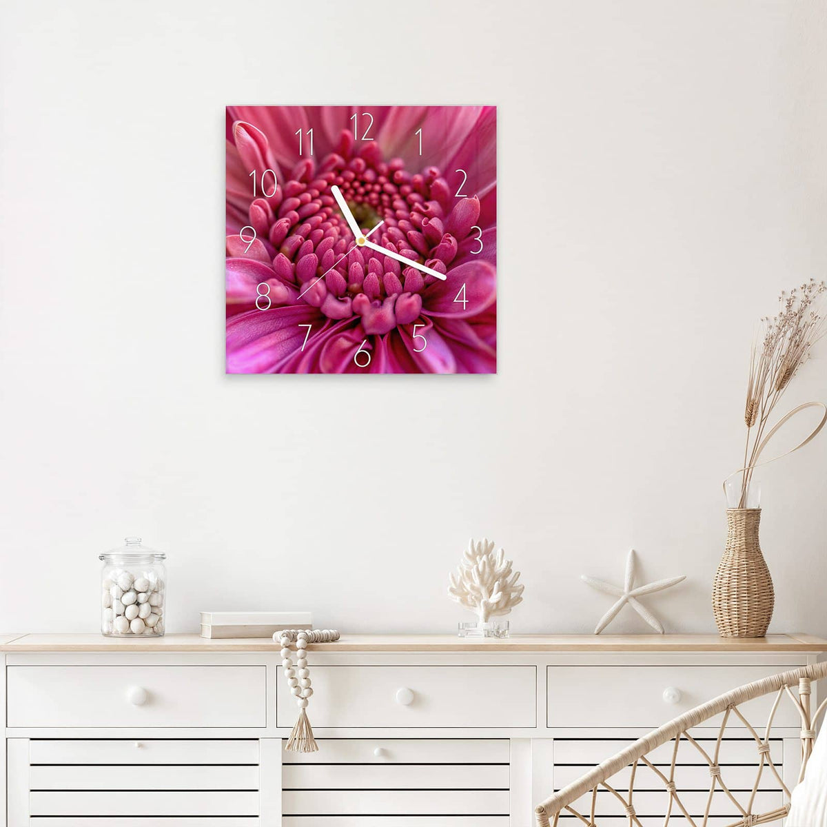 Quadratische Wanduhr aus Glas Pinke Blütenspirale mit Ziffernblatt Elegant über einem weißen Sideboard
