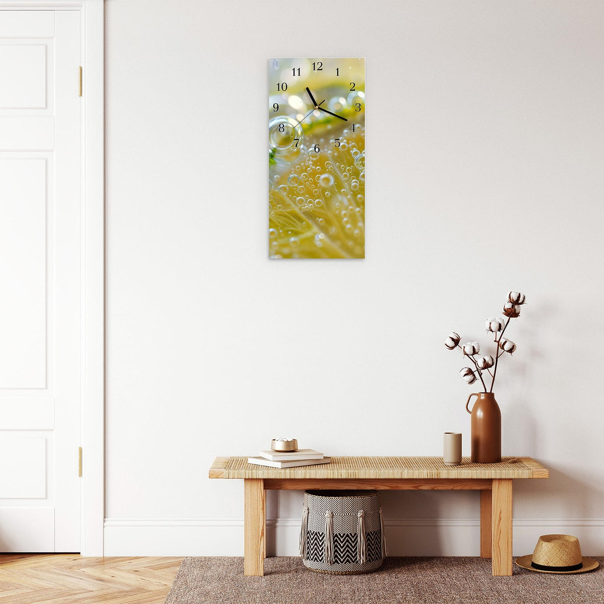 Wanduhr aus Glas im Hochformat Zitrone im Sprudel mit Ziffernblatt Klassisch über einer Holzbank im Flur