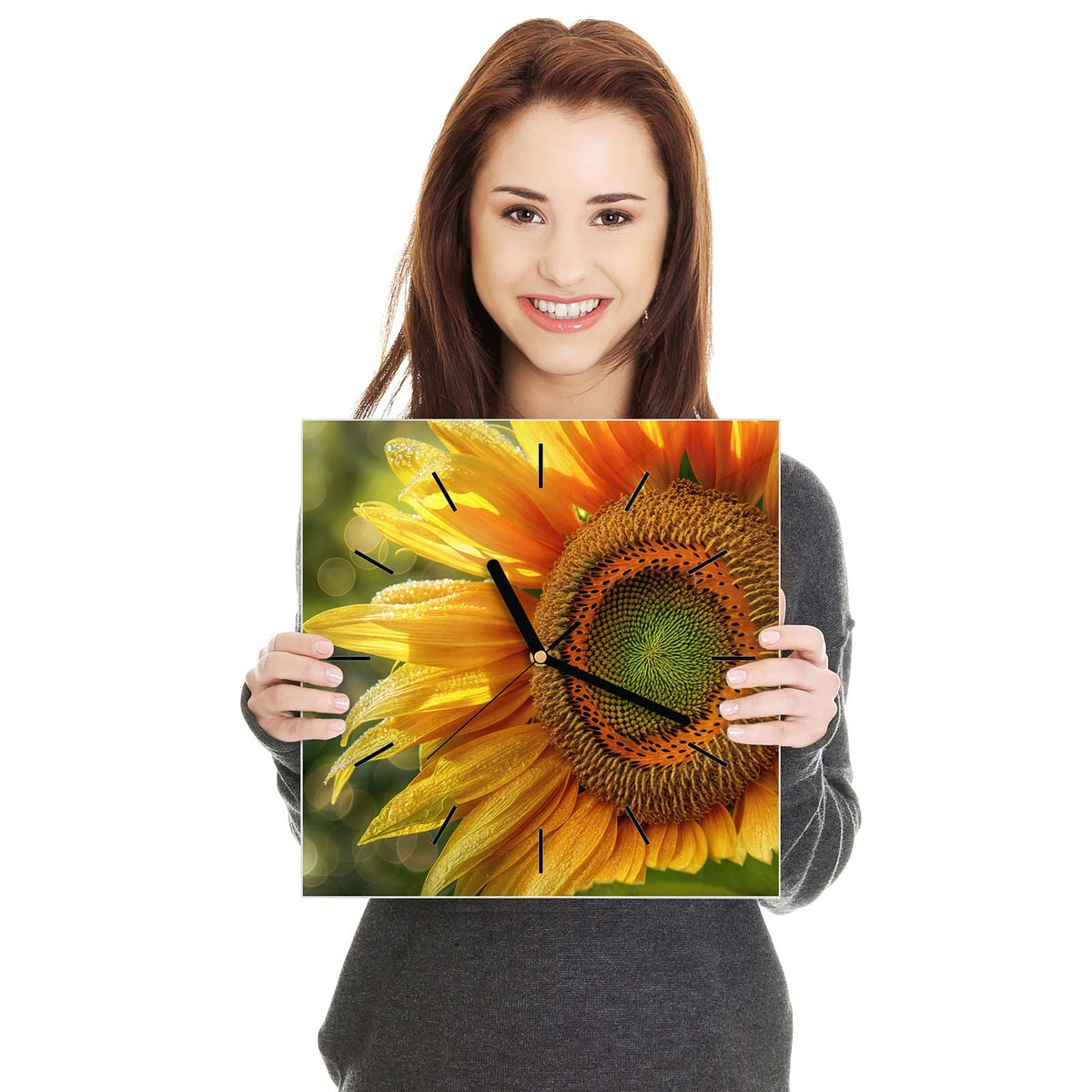 Quadratische Wanduhr aus Glas Sonnenblume mit Tau in zwei Händen gehalten – Größenvergleich, 30 × 30 cm