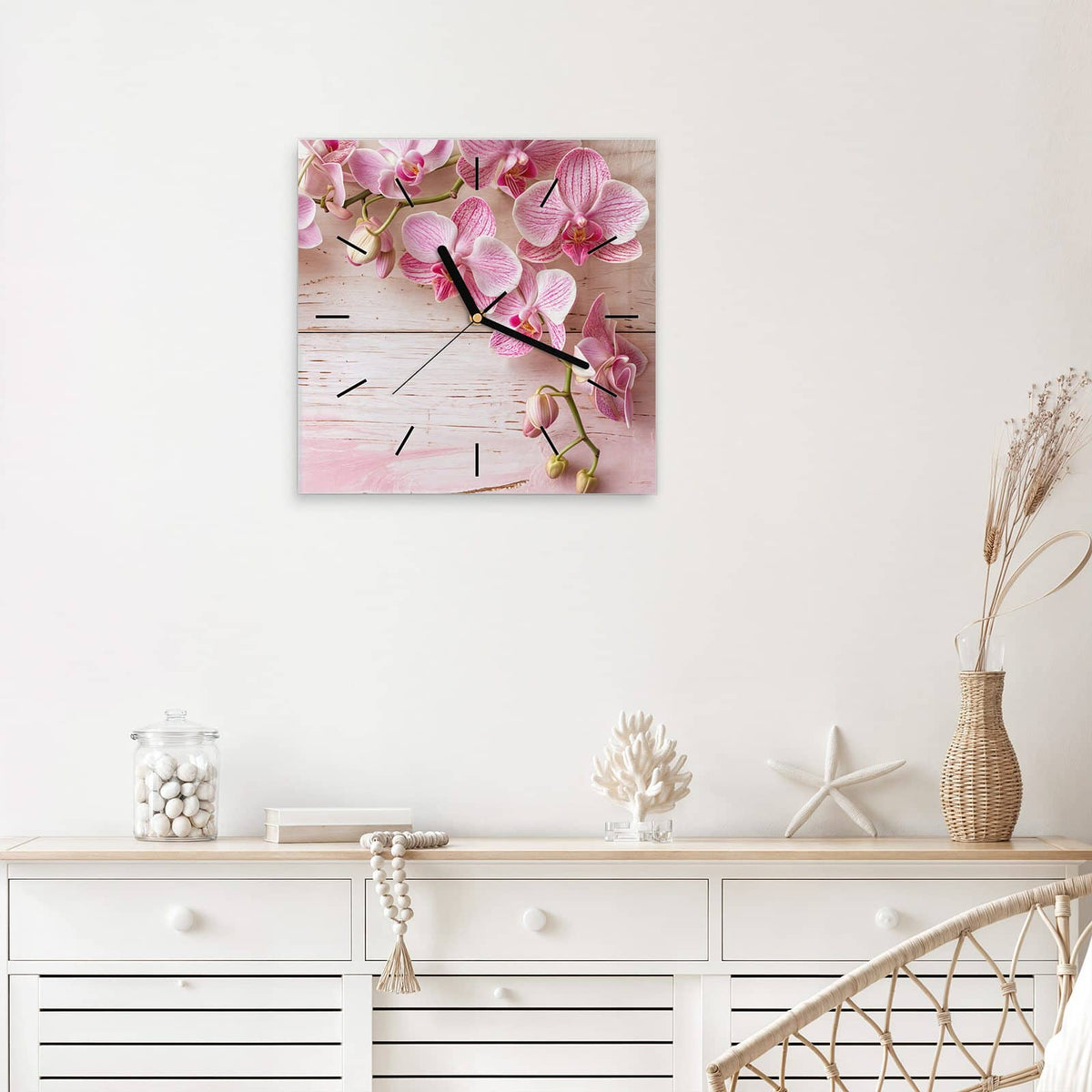 Quadratische Wanduhr aus Glas Orchideen auf Rosa mit Ziffernblatt Linie über einem weißen Sideboard