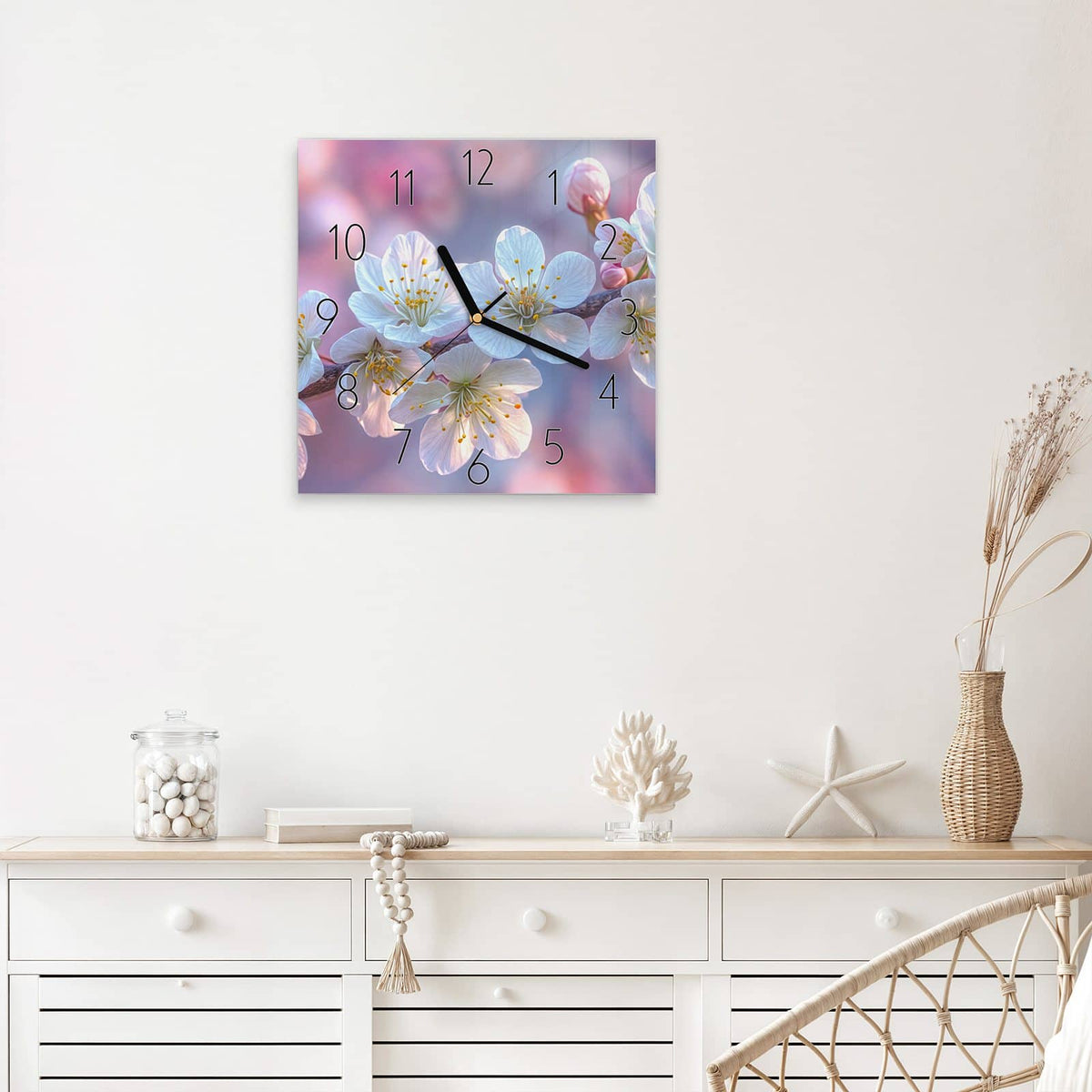 Quadratische Wanduhr aus Glas Weißer Blütenzweig mit Ziffernblatt Elegant über einem weißen Sideboard