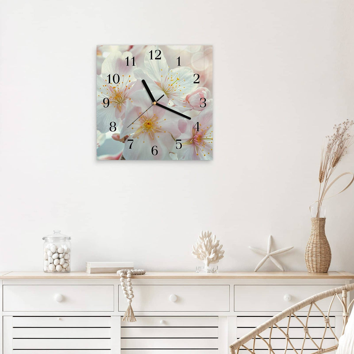 Quadratische Wanduhr aus Glas Weiße Frühlingsblüten mit Ziffernblatt Klassisch über einem weißen Sideboard