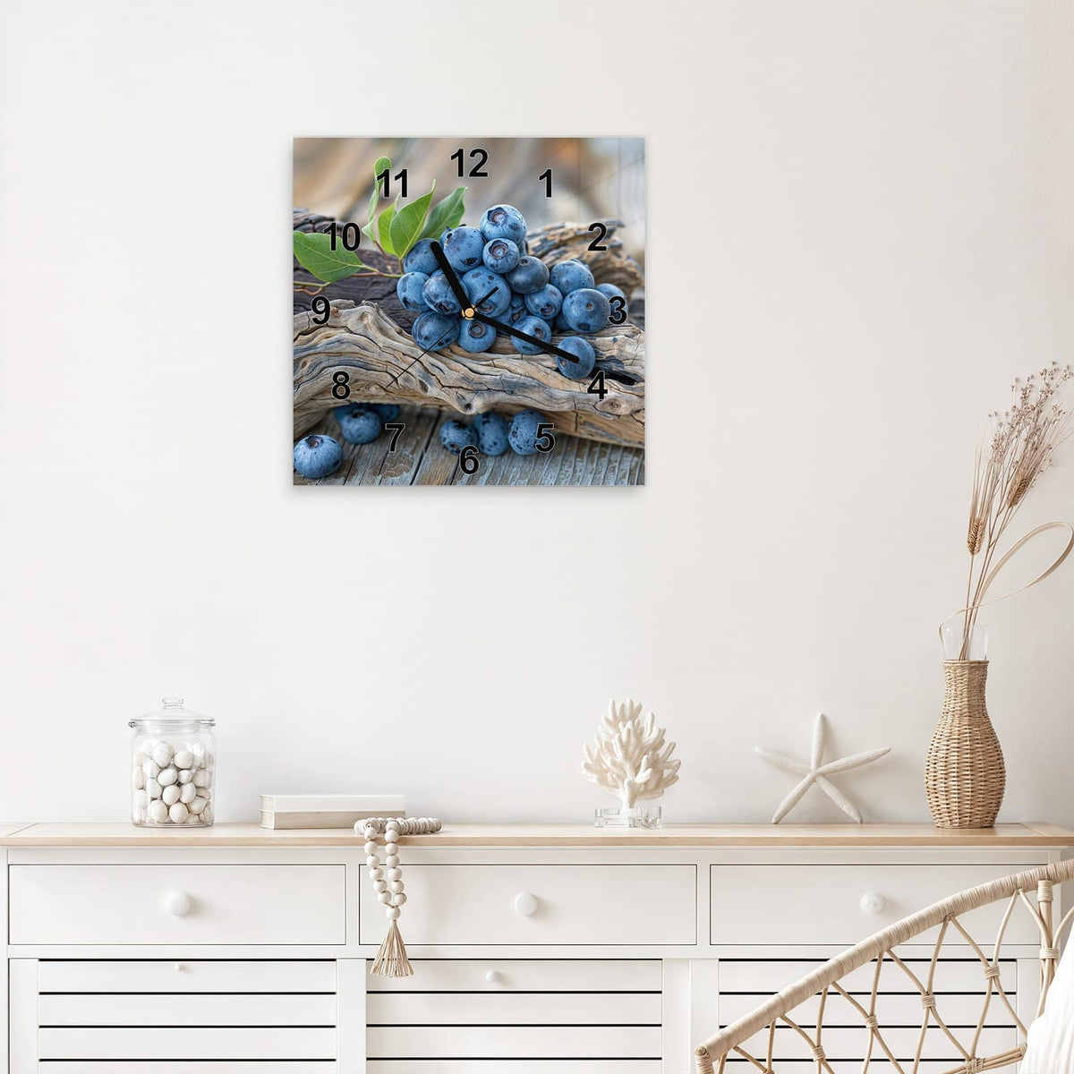 Quadratische Wanduhr aus Glas Treibholz und Blaubeeren mit Ziffernblatt Modern über einem weißen Sideboard