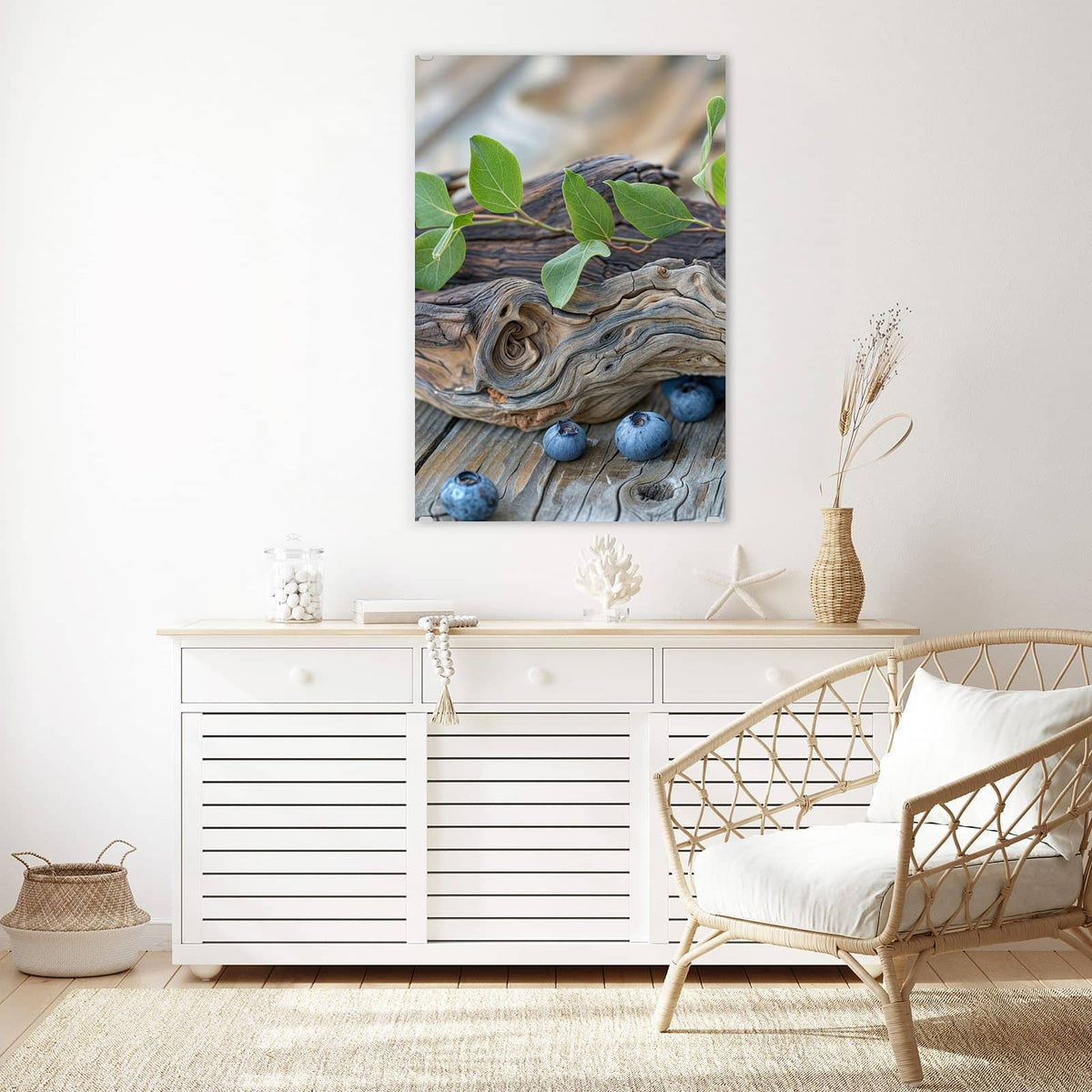 Glasbild Treibholz und Blaubeeren an der Wand – Haufen Blaubeeren mit grünen Blättern auf verwittertem Treibholzast, darunter graue Holzdielen