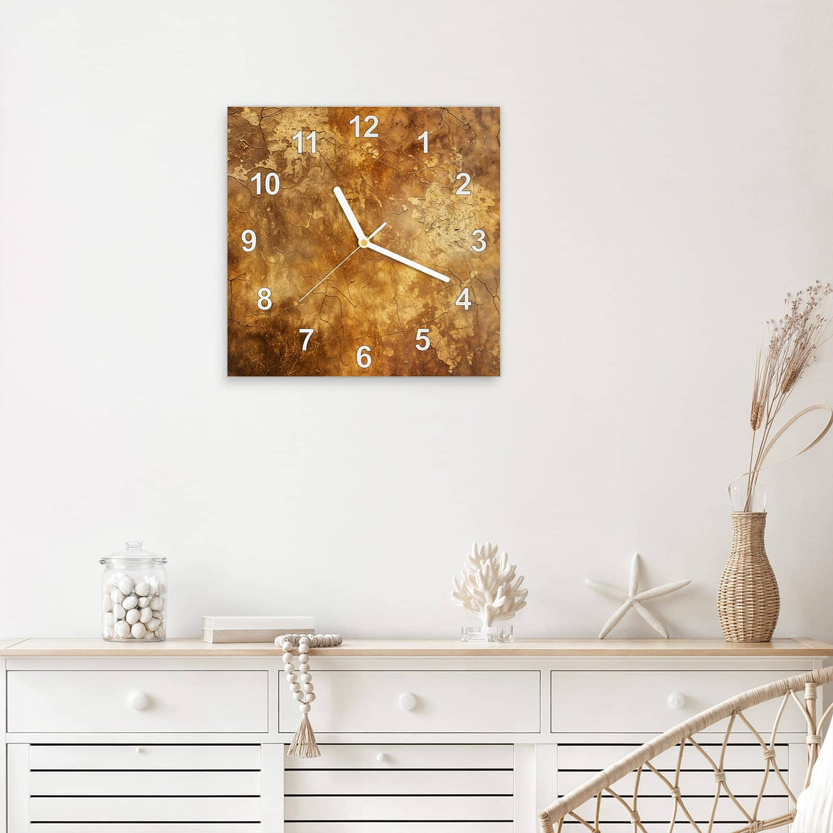 Quadratische Wanduhr aus Glas Risse in Ockerbraun mit Ziffernblatt Modern über einem weißen Sideboard