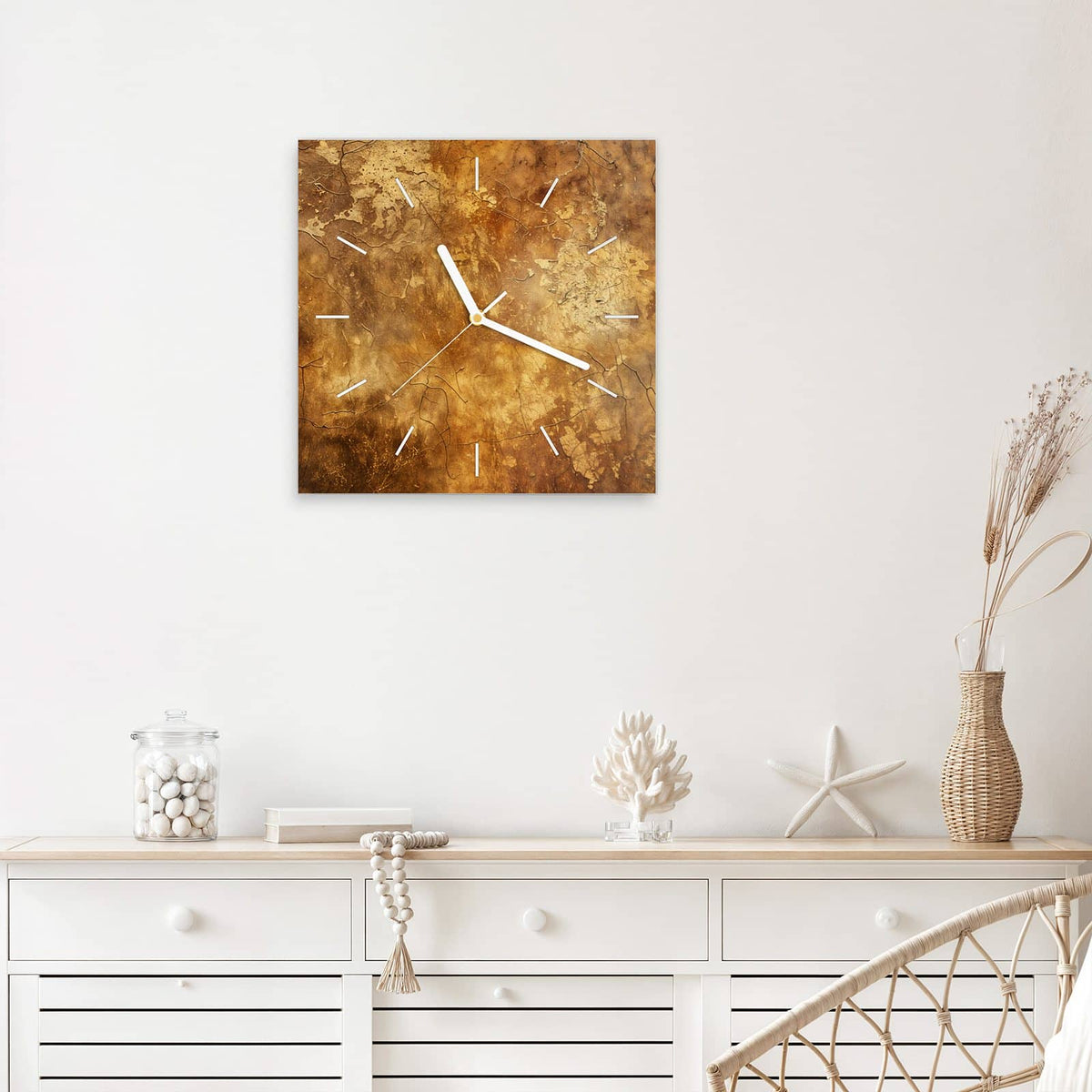 Quadratische Wanduhr aus Glas Risse in Ockerbraun mit Ziffernblatt Linie über einem weißen Sideboard
