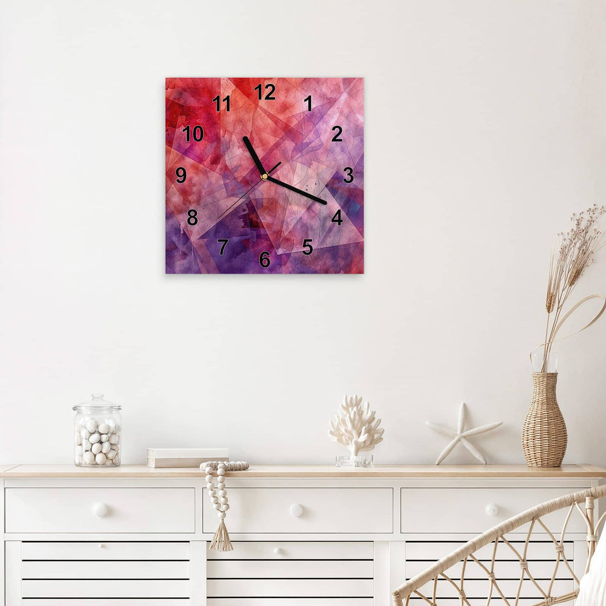 Quadratische Wanduhr aus Glas Rote Aquarellpolygone mit Ziffernblatt Modern über einem weißen Sideboard