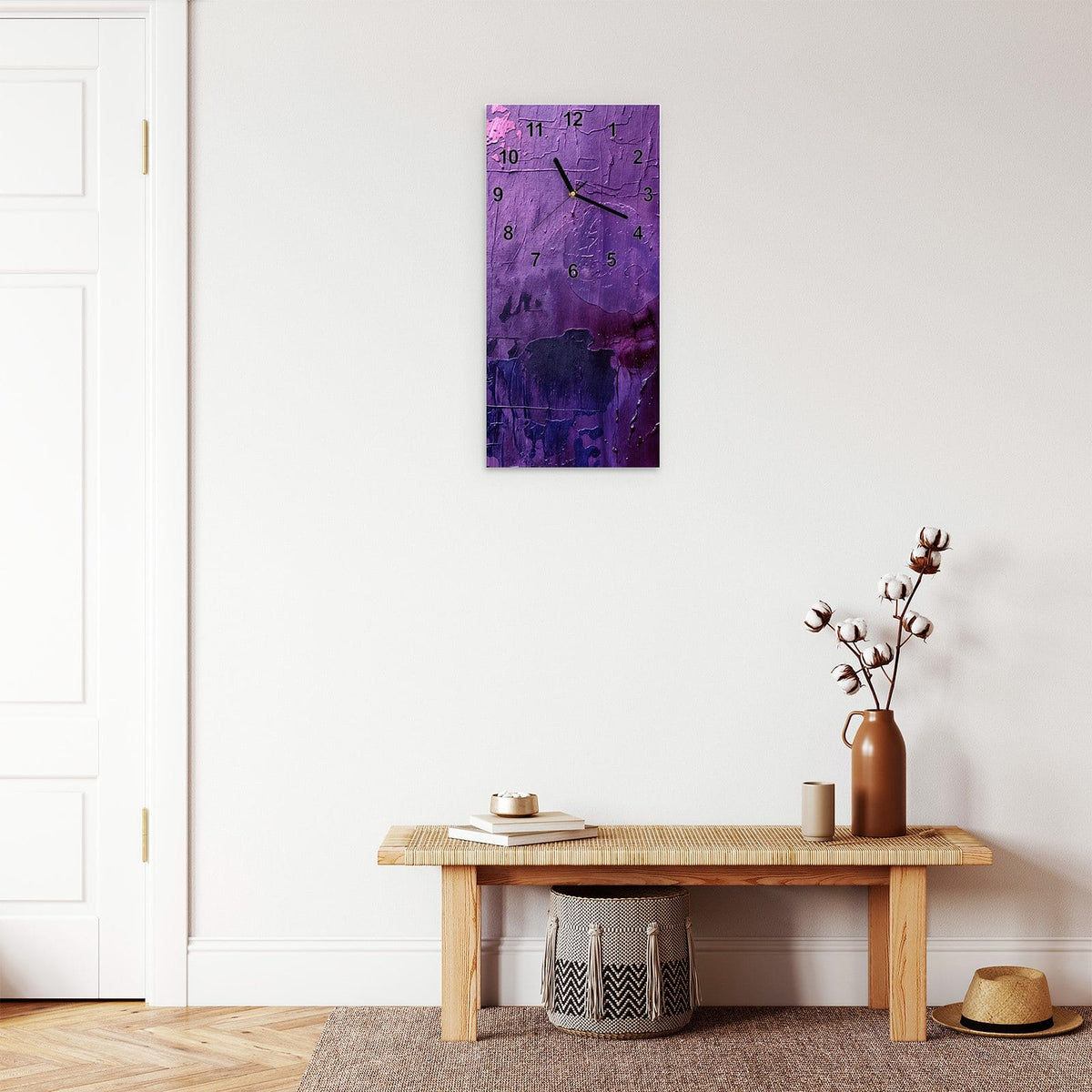 Wanduhr aus Glas im Hochformat Violette Farbschichten mit Ziffernblatt Modern über einer Holzbank im Flur
