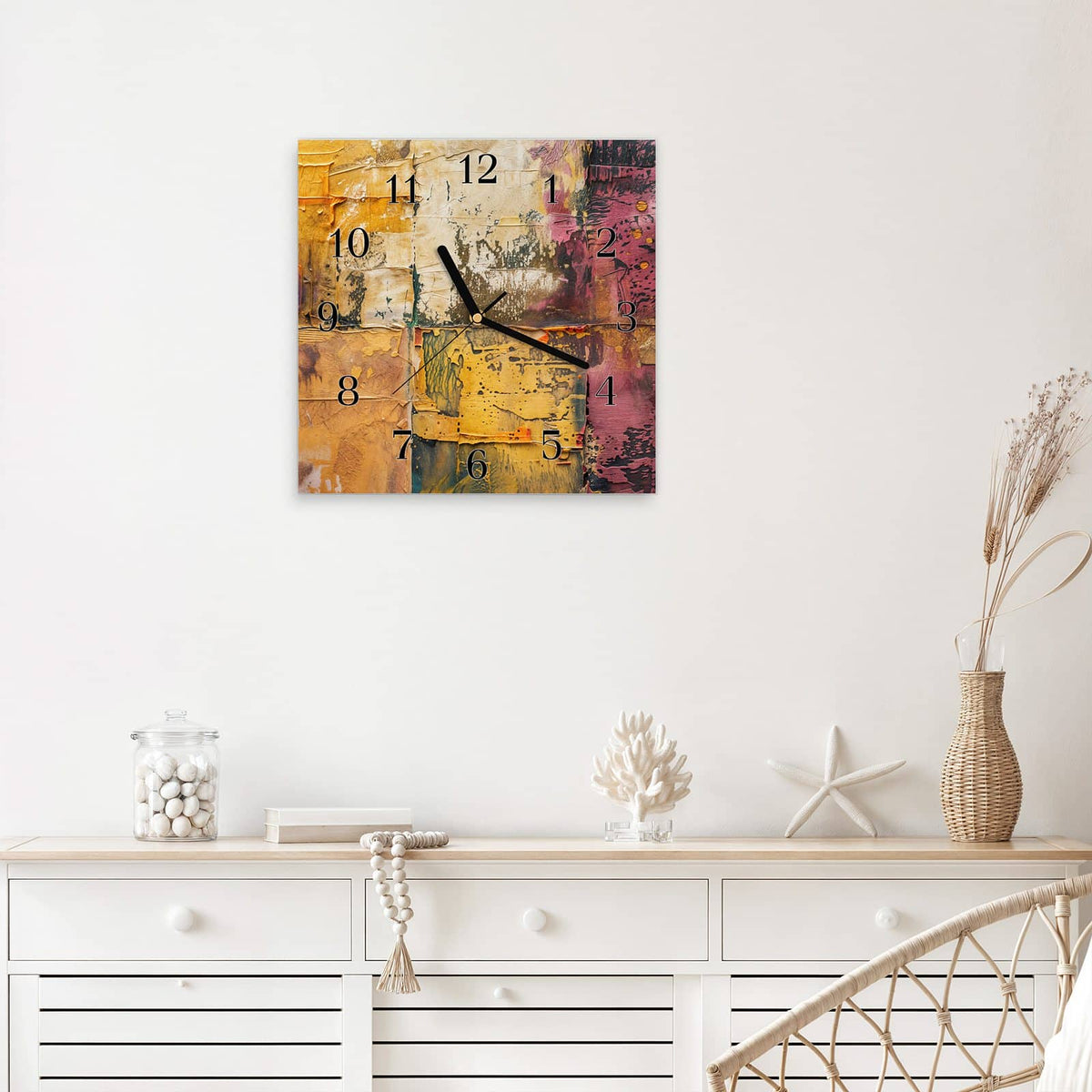 Quadratische Wanduhr aus Glas Papiercollage in Ocker mit Ziffernblatt Klassisch über einem weißen Sideboard