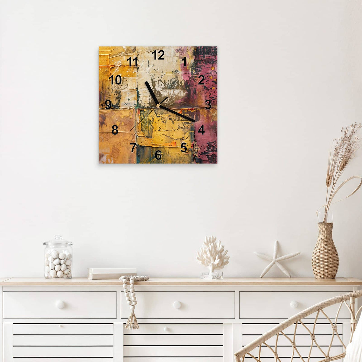 Quadratische Wanduhr aus Glas Papiercollage in Ocker mit Ziffernblatt Modern über einem weißen Sideboard