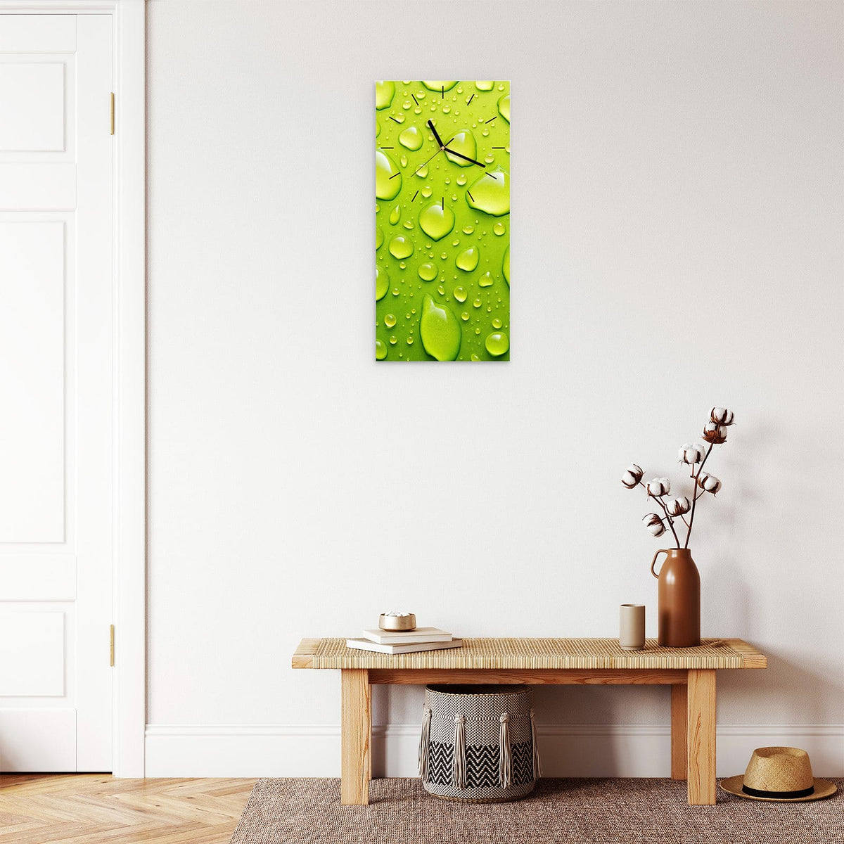 Wanduhr aus Glas im Hochformat Tropfen auf Grün mit Ziffernblatt Linie über einer Holzbank im Flur