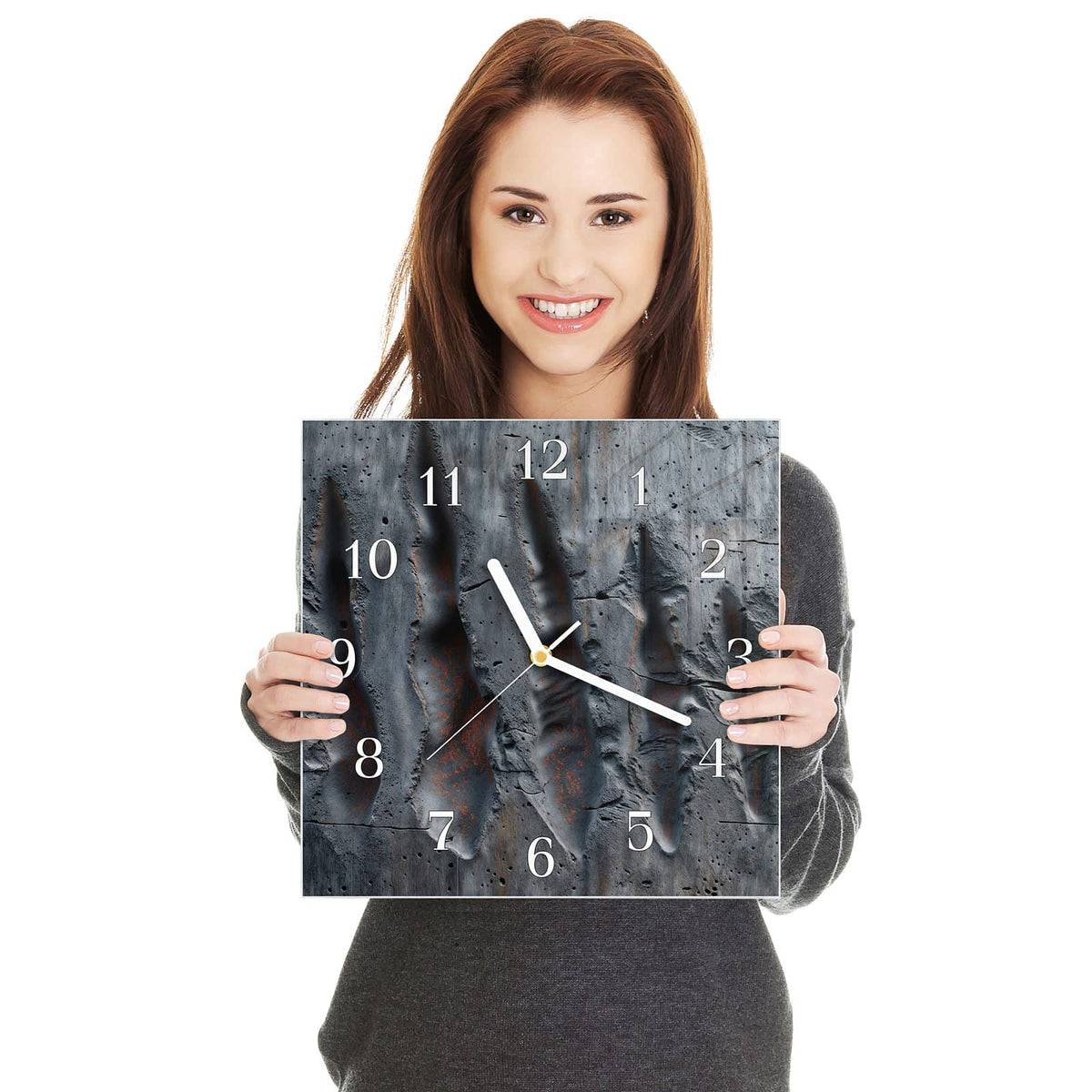 Quadratische Wanduhr aus Glas Rostspuren im Beton in zwei Händen gehalten – Größenvergleich, 30 × 30 cm