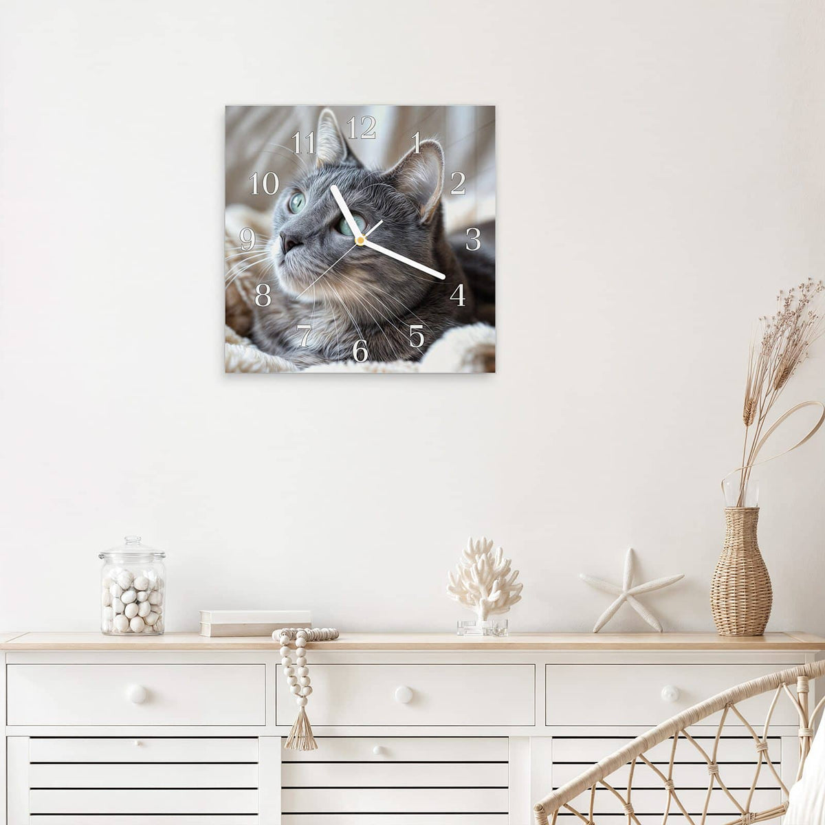 Quadratische Wanduhr aus Glas Graue Katze auf Decke mit Ziffernblatt Klassisch über einem weißen Sideboard