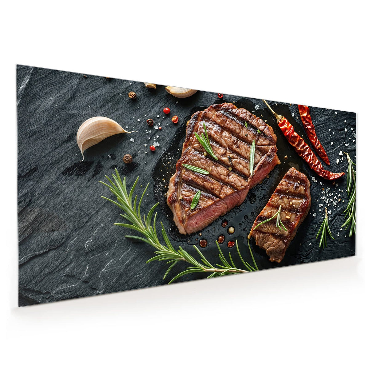 Küchenrückwand aus Glas im Hochformat mit Motiv Saftiges Rosmarinsteak: Zwei gegrillte Steaks mit Rosmarin, Chilischoten und Salz auf schwarzem Schiefer