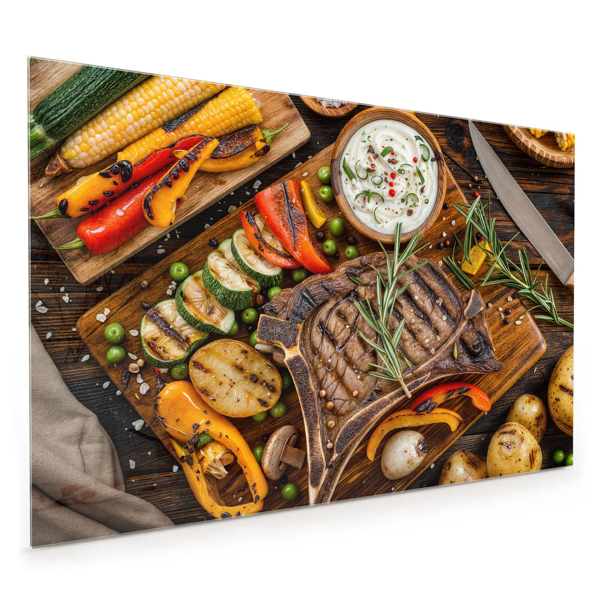 Küchenrückwand aus Glas im Hochformat: Gegrilltes T-Bone-Steak mit Rosmarin auf Holzbrett, daneben Grillgemüse, Mais, Kartoffeln und eine Dip-Schale.