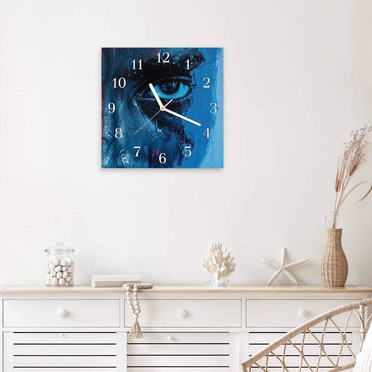 Quadratische Wanduhr aus Glas Gemaltes Auge in Blau mit Ziffernblatt Klassisch über einem weißen Sideboard