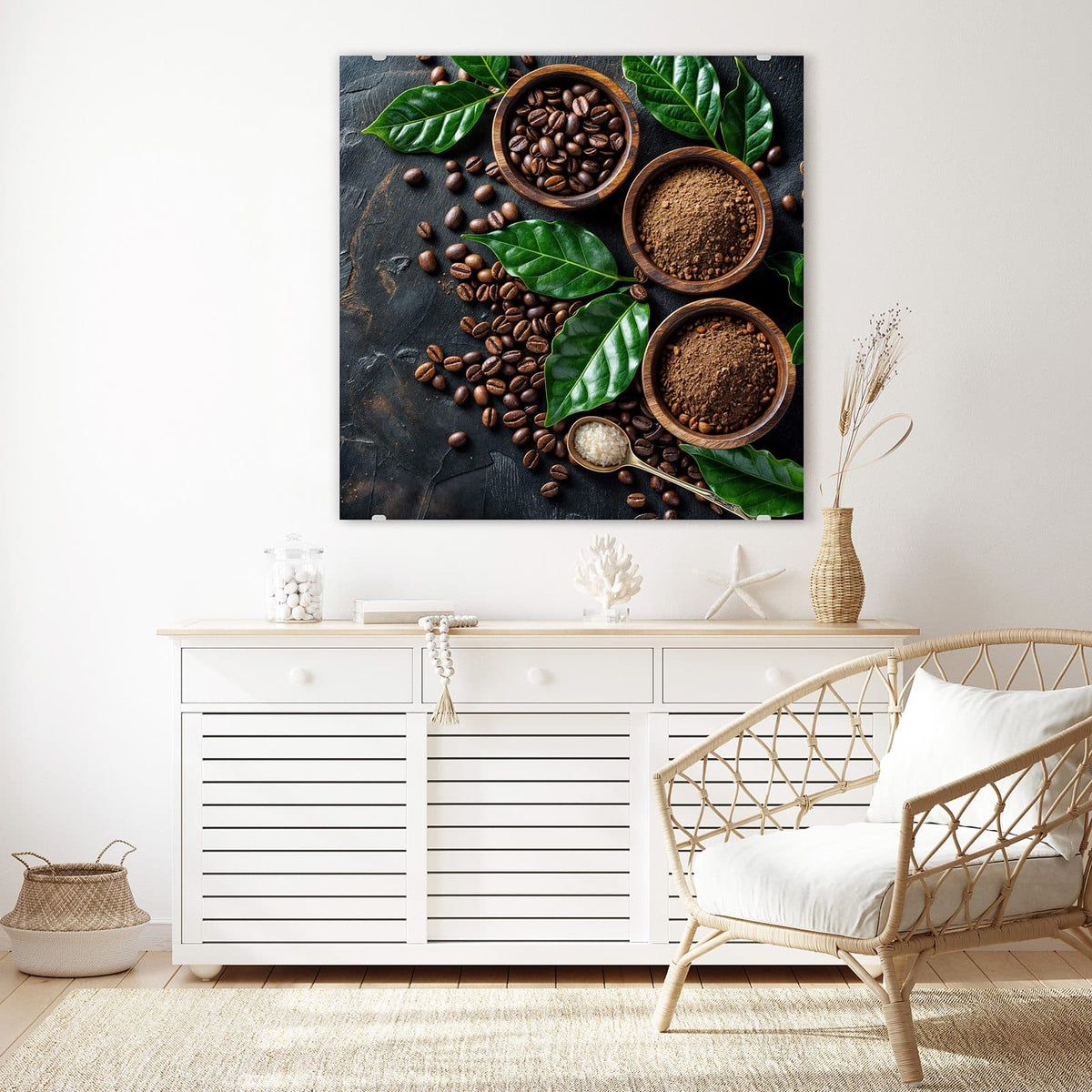 Glasbild Kaffeebohnen und Blätter an der Wand – Drei Holzschalen mit Kaffeebohnen und Kaffeepulver, dazwischen ganze Bohnen und große grüne Kaffeeblätter auf dunklem Stein