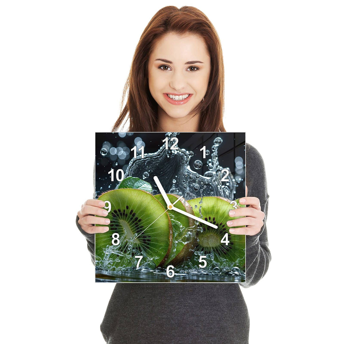Quadratische Wanduhr aus Glas Kiwischeiben im Spritzer in zwei Händen gehalten – Größenvergleich, 30 × 30 cm