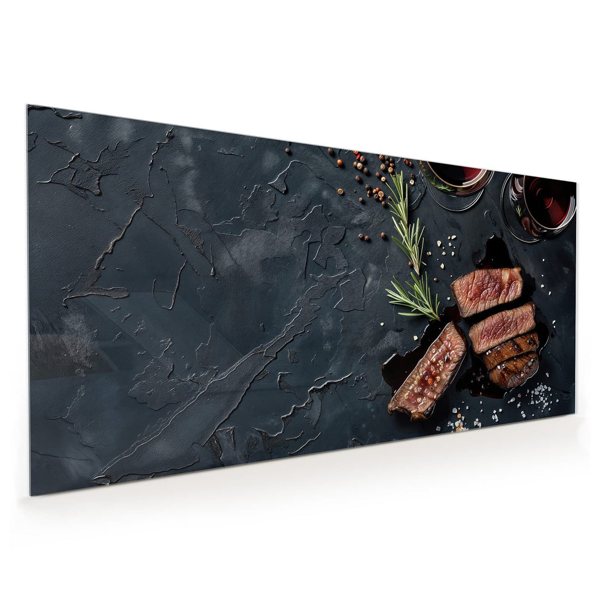 Küchenrückwand aus Glas im Hochformat: Aufgeschnittenes Steak neben zwei Rotweingläsern, Rosmarin und Salz auf Schiefer