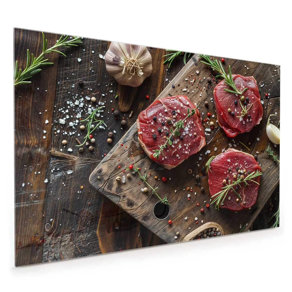 Küchenrückwand aus Glas im Hochformat mit Motiv Steaks mit Knoblauch: Drei rohe Rindersteaks auf Holzbrett mit Rosmarin, Knoblauch, Salz und Pfefferkörnern