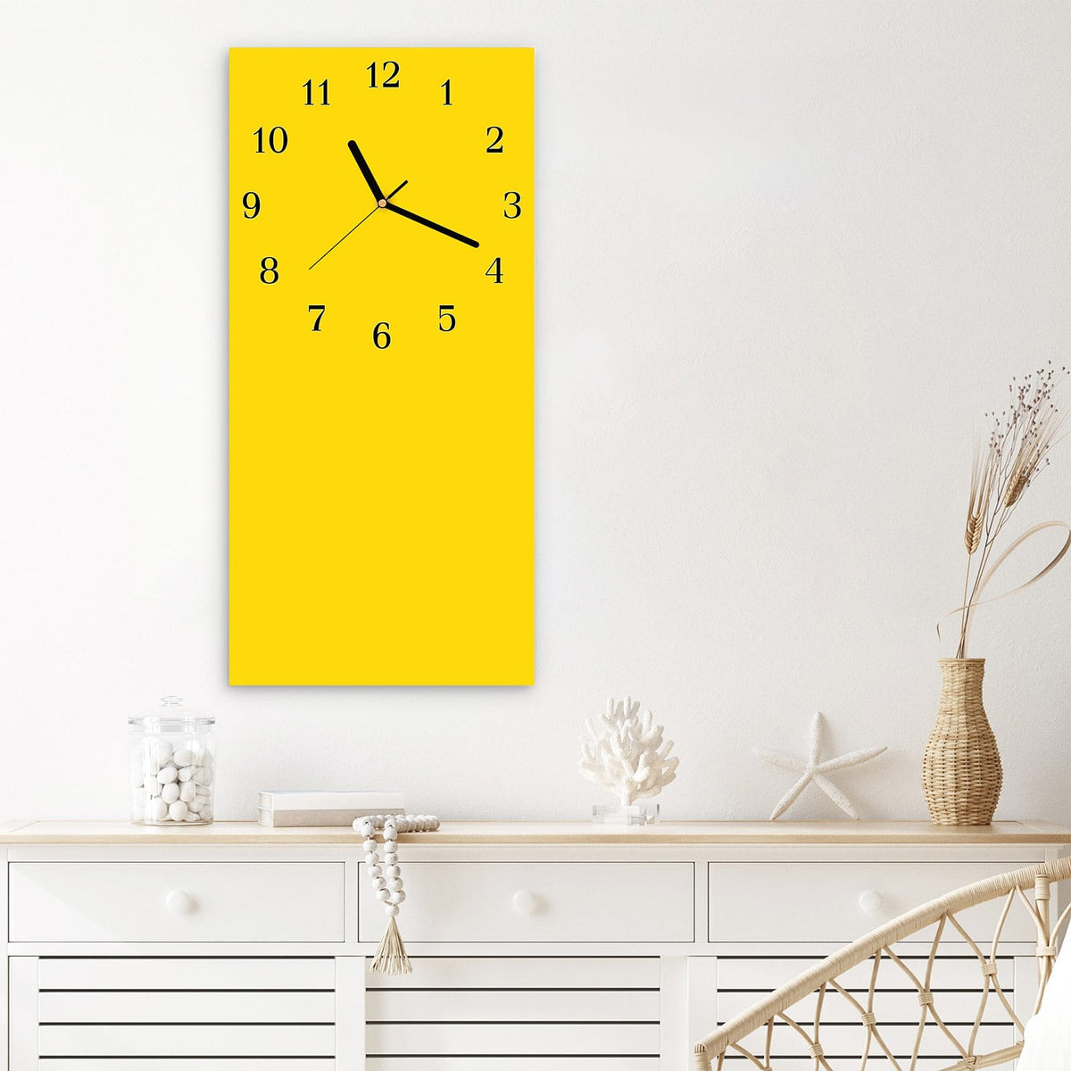 Wanduhr aus Glas im Hochformat Kanariengelb mit Ziffernblatt Klassisch über einem weißen Sideboard