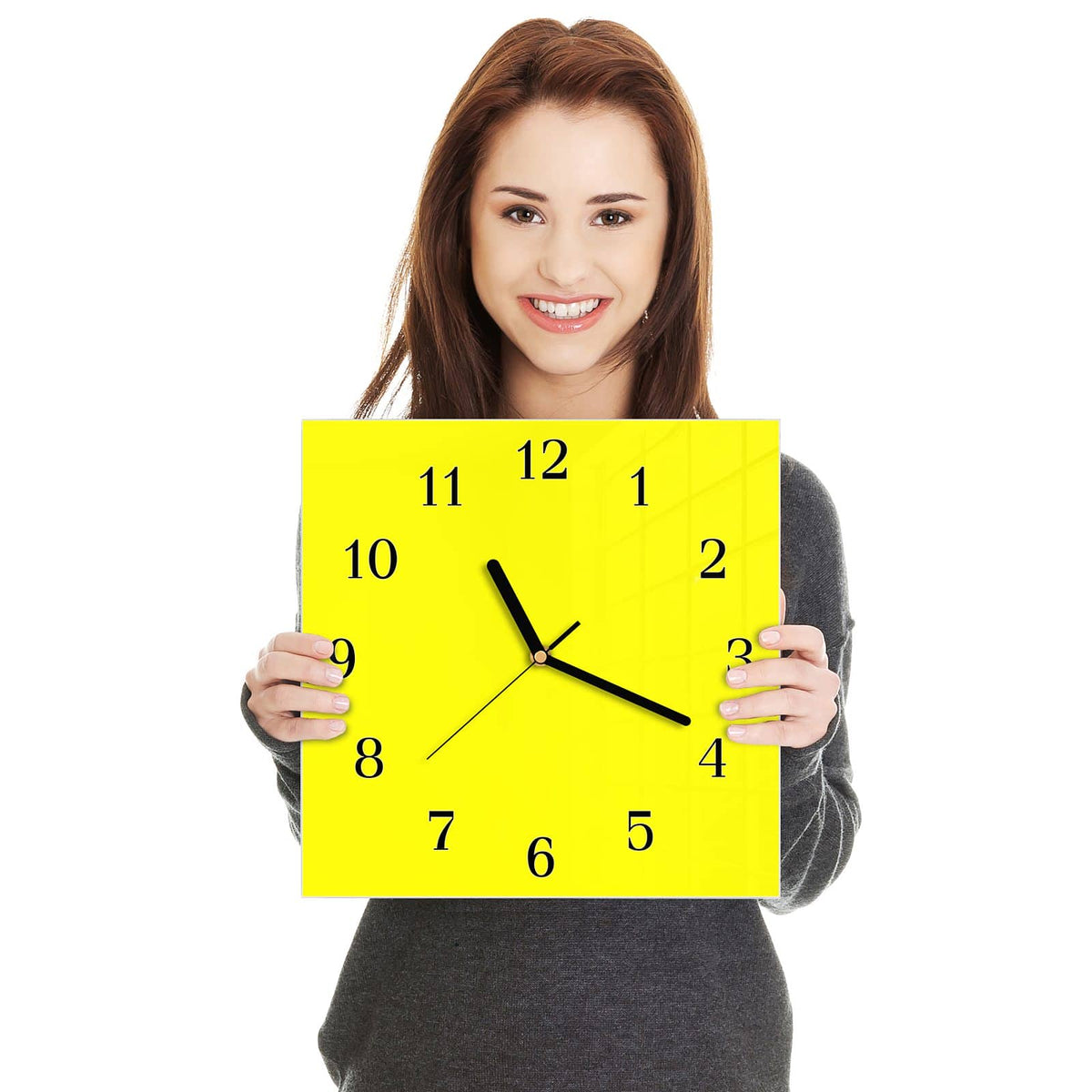 Quadratische Wanduhr aus Glas Zitronengelb in zwei Händen gehalten – Größenvergleich, 30 × 30 cm