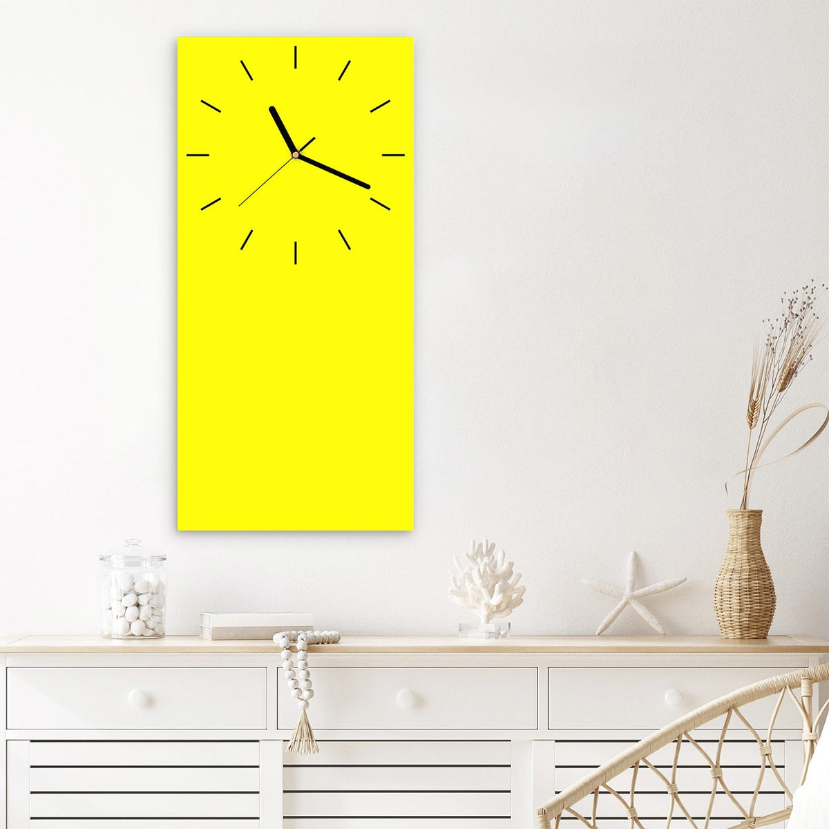 Wanduhr aus Glas im Hochformat Zitronengelb mit Ziffernblatt Linie über einem weißen Sideboard
