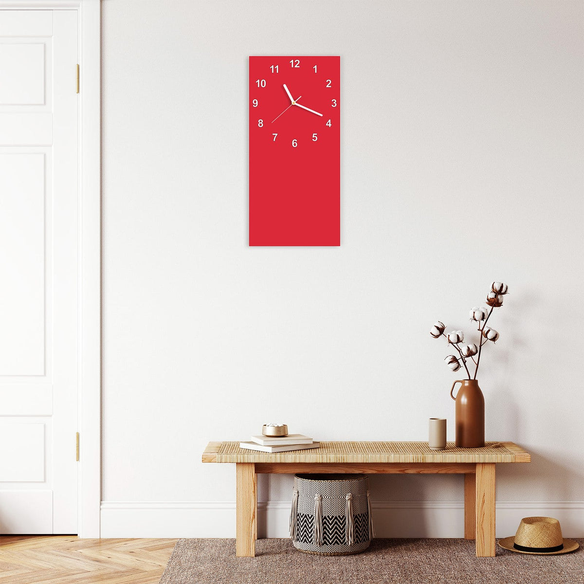 Wanduhr aus Glas im Hochformat Pinkroter Hintergrund mit Ziffernblatt Modern über einer Holzbank im Flur