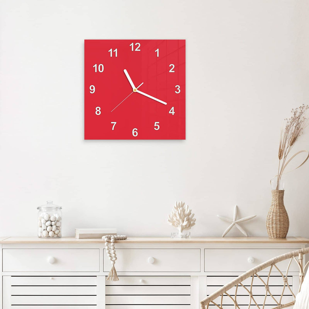 Quadratische Wanduhr aus Glas Pinkroter Hintergrund mit Ziffernblatt Modern über einem weißen Sideboard