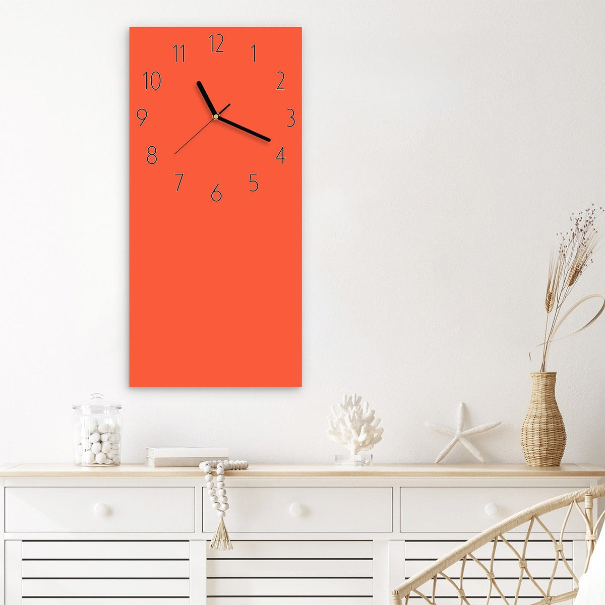 Wanduhr aus Glas im Hochformat Rotoranger Hintergrund mit Ziffernblatt Elegant über einem weißen Sideboard